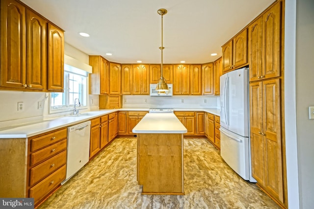 kitchen featuring a center island, pendant lighting, white appliances, and sink