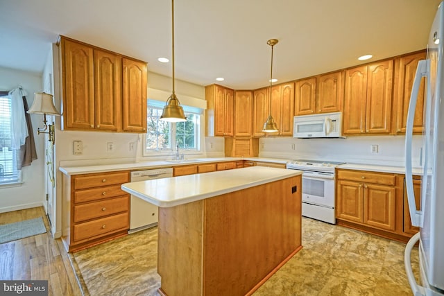 kitchen with sink, a center island, pendant lighting, white appliances, and light hardwood / wood-style floors