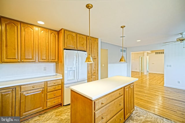 kitchen with ceiling fan, white fridge with ice dispenser, light hardwood / wood-style flooring, decorative light fixtures, and a kitchen island