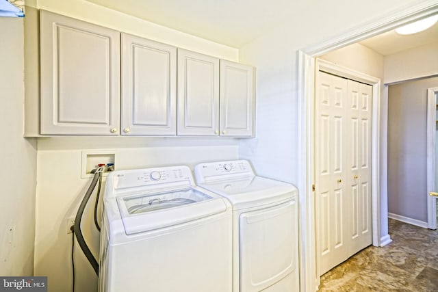 clothes washing area with cabinets and independent washer and dryer