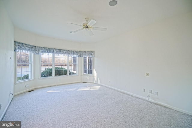 carpeted spare room featuring ceiling fan