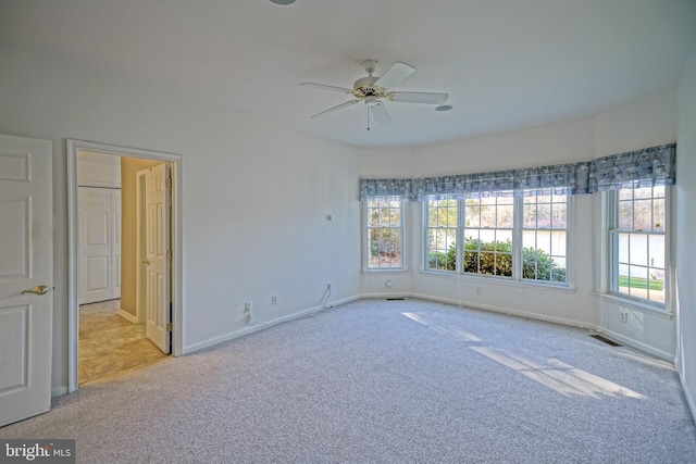 carpeted empty room featuring ceiling fan