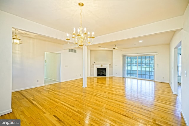 unfurnished living room featuring ceiling fan with notable chandelier and light wood-type flooring