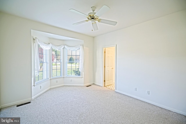 carpeted spare room featuring ceiling fan