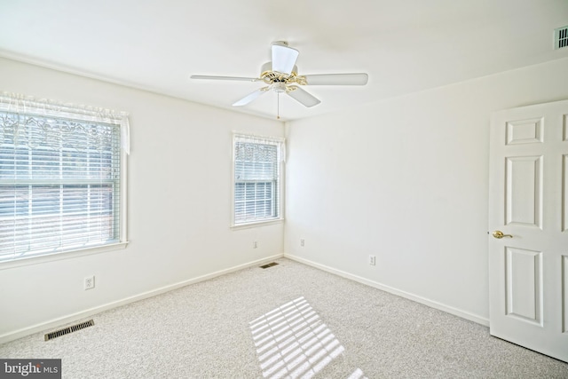 unfurnished room with ceiling fan, a healthy amount of sunlight, and light carpet