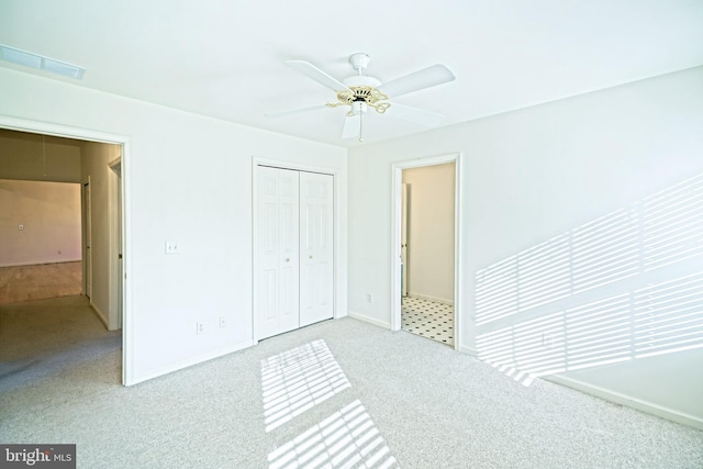 unfurnished bedroom with ceiling fan, light carpet, and a closet