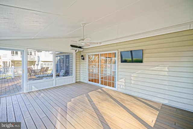 unfurnished sunroom featuring ceiling fan, a healthy amount of sunlight, and vaulted ceiling