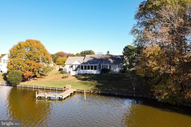 view of dock with a yard and a water view