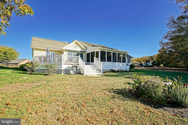 view of front of property featuring a front yard, a wooden deck, and a sunroom