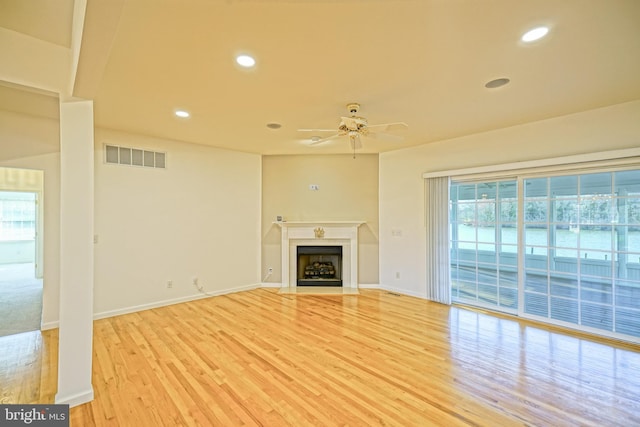 unfurnished living room featuring ceiling fan and light hardwood / wood-style floors