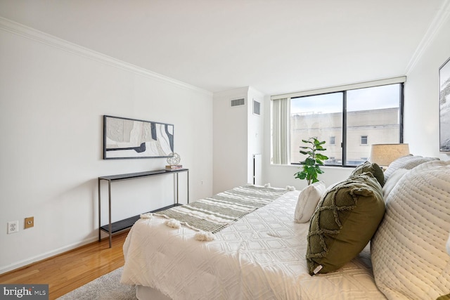 bedroom with ornamental molding and hardwood / wood-style floors