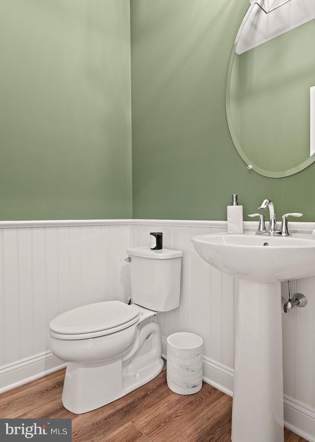 bathroom with hardwood / wood-style flooring, toilet, and sink