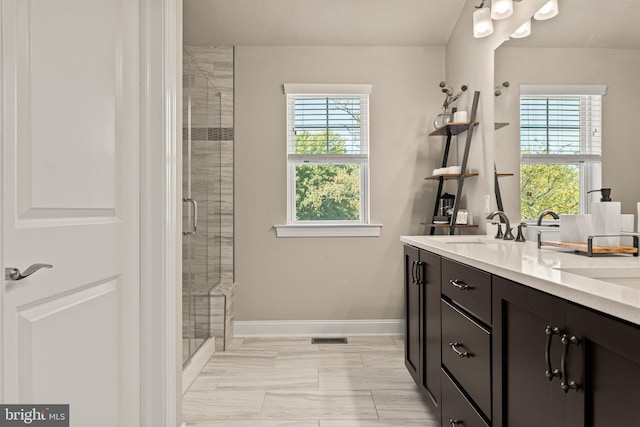 bathroom with an enclosed shower, a wealth of natural light, and vanity