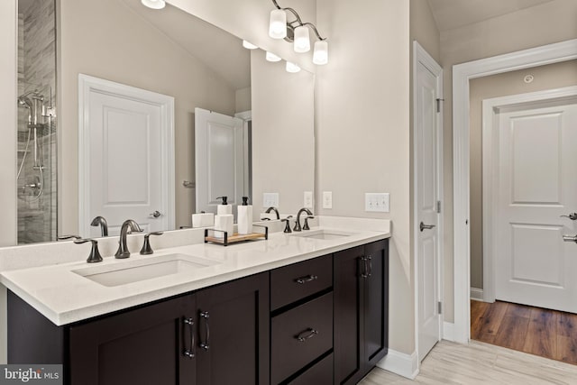 bathroom with vanity, vaulted ceiling, and wood-type flooring