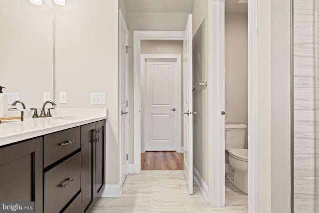 bathroom with hardwood / wood-style floors, vanity, and toilet