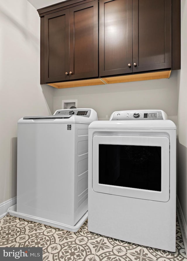 laundry area featuring cabinets, washing machine and clothes dryer, and light tile patterned flooring