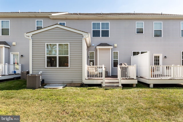 back of property with cooling unit, a lawn, and a deck