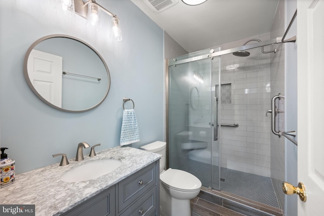 bathroom with vanity, wood-type flooring, an enclosed shower, and toilet