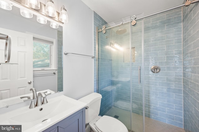 bathroom featuring vanity, an enclosed shower, and toilet