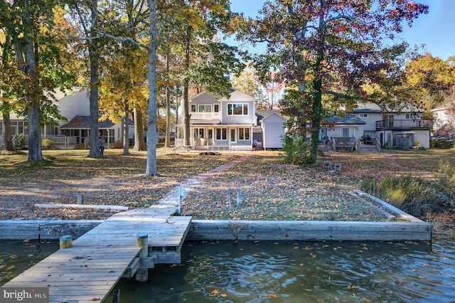 view of dock with a balcony and a water view