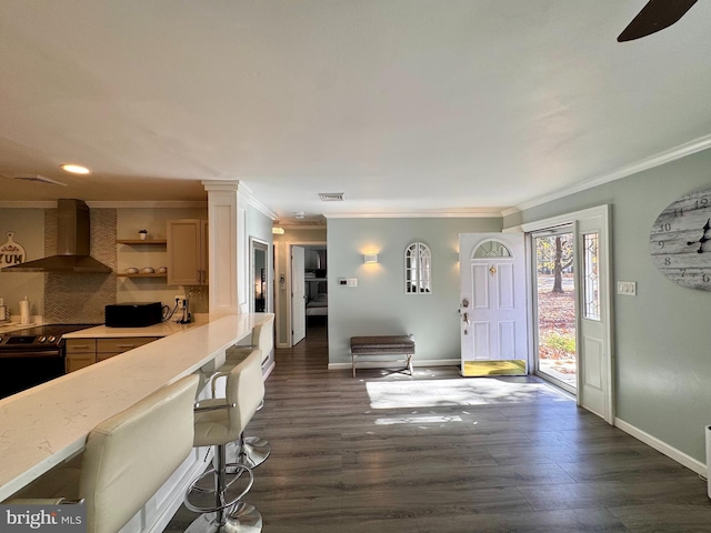 kitchen featuring dark hardwood / wood-style flooring, electric stove, decorative backsplash, crown molding, and wall chimney range hood