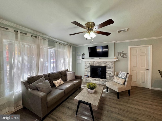 living room with dark hardwood / wood-style flooring, ceiling fan, crown molding, and a fireplace