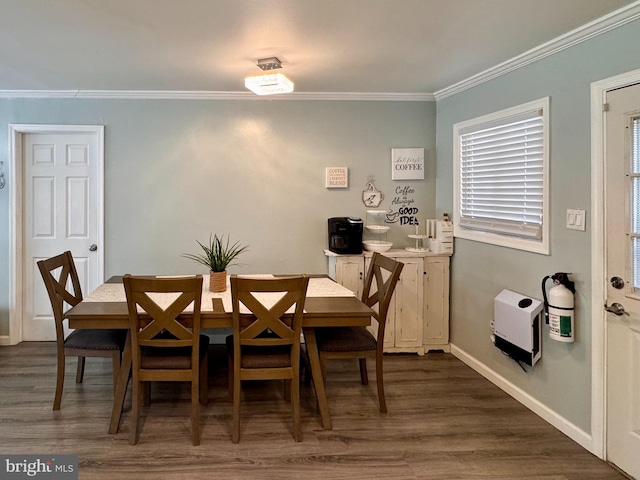 dining room with dark wood-type flooring and crown molding