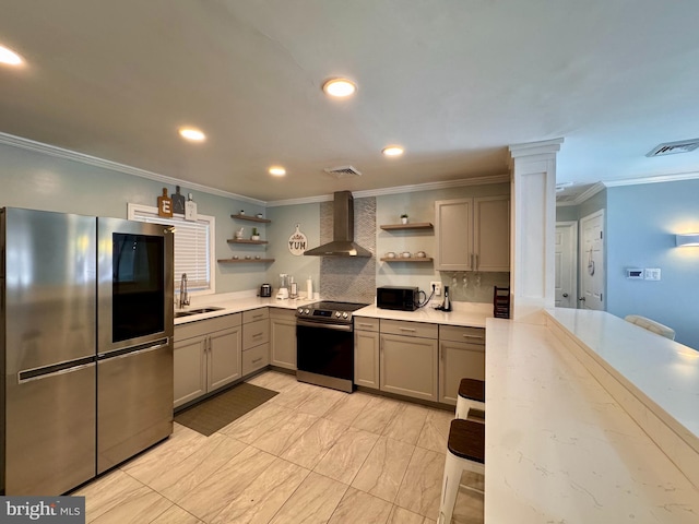 kitchen featuring stainless steel appliances, gray cabinets, wall chimney exhaust hood, and ornate columns