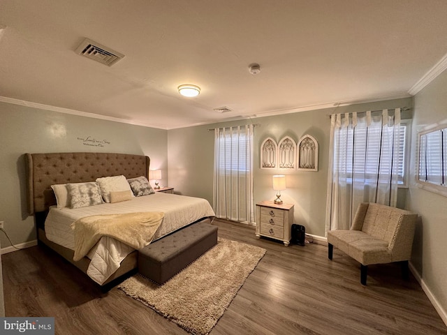 bedroom featuring dark hardwood / wood-style flooring, multiple windows, and ornamental molding