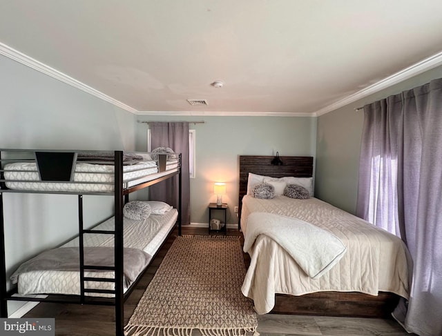 bedroom with crown molding and dark hardwood / wood-style flooring