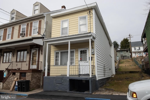 townhome / multi-family property featuring cooling unit and covered porch