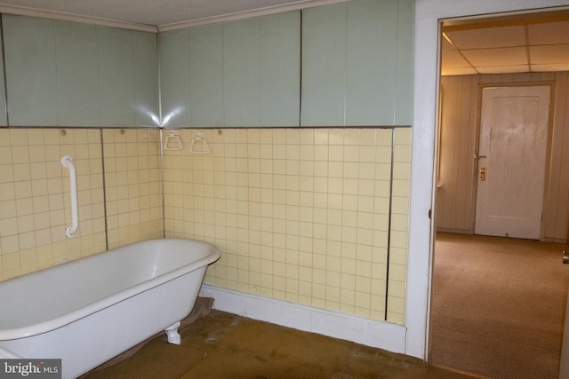 bathroom featuring a tub to relax in and tile walls