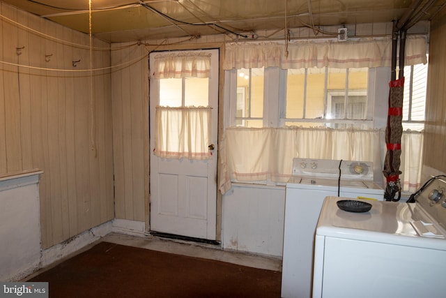 laundry room with wood walls and washer / dryer