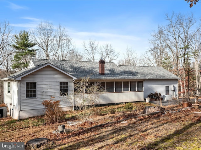 rear view of house featuring a sunroom and central AC unit