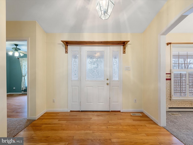 entryway with light hardwood / wood-style floors and baseboard heating