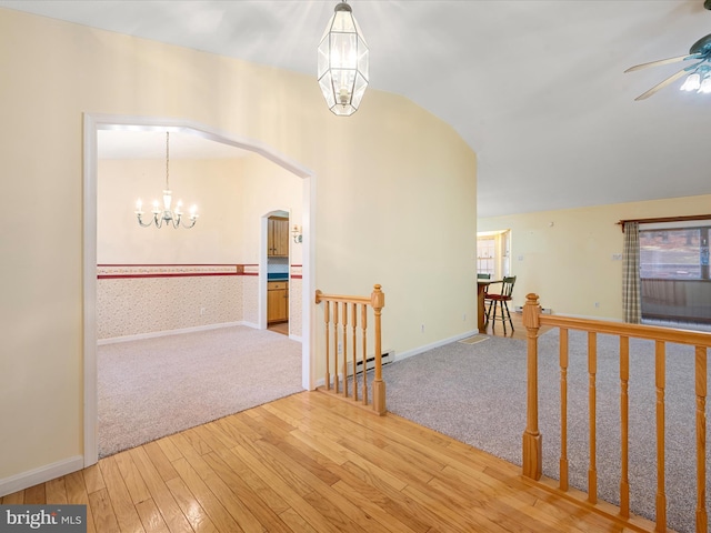 corridor featuring baseboard heating, wood-type flooring, vaulted ceiling, and a notable chandelier