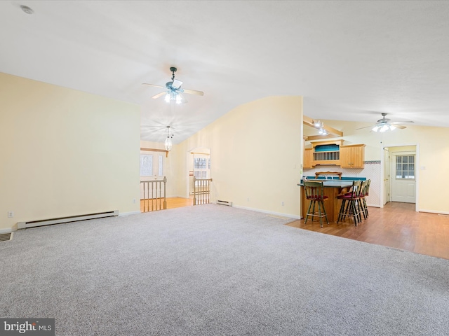 living room with lofted ceiling, light hardwood / wood-style flooring, ceiling fan, and a baseboard heating unit