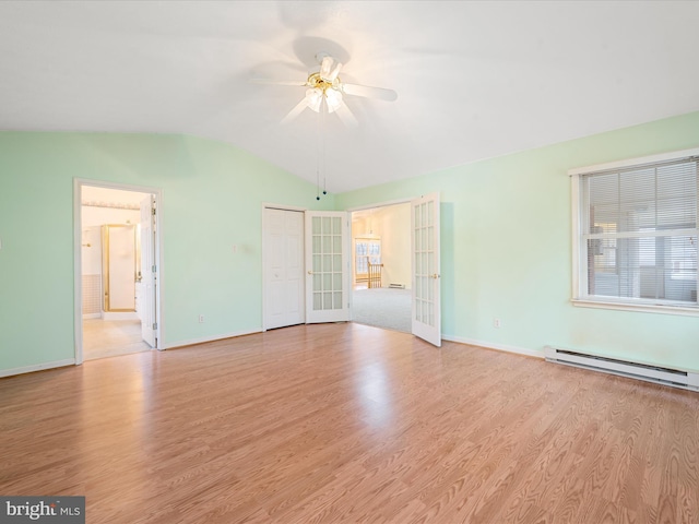 interior space with lofted ceiling, a baseboard heating unit, french doors, ceiling fan, and light hardwood / wood-style floors