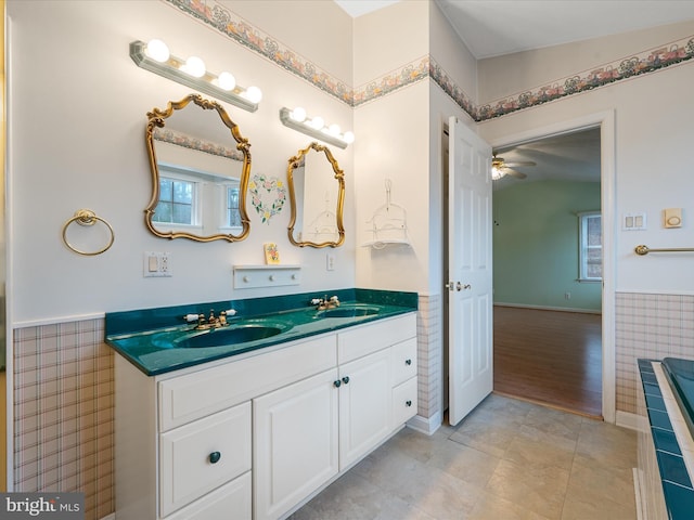 bathroom featuring ceiling fan, plenty of natural light, vanity, and lofted ceiling