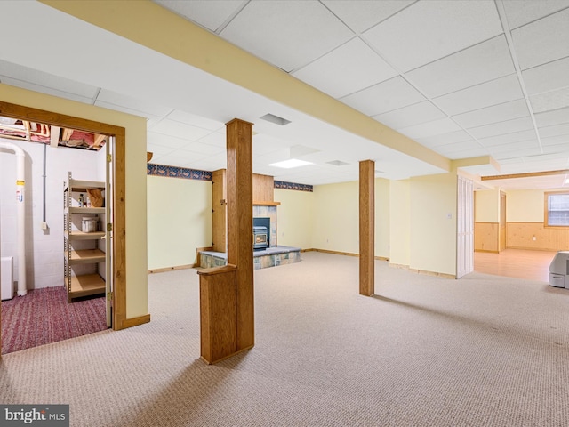 basement featuring a drop ceiling and carpet floors