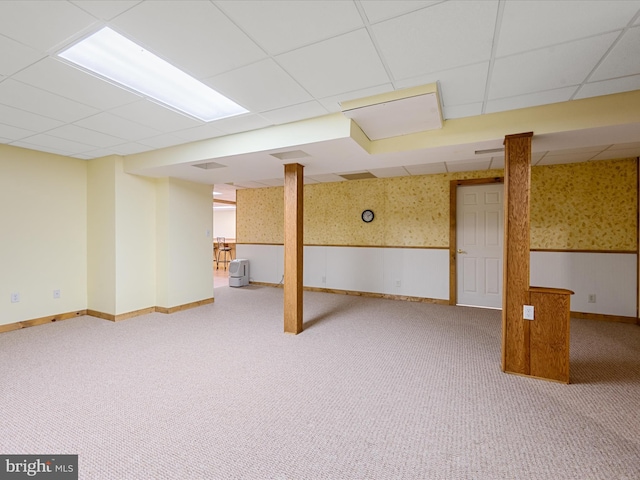 basement featuring a drop ceiling and carpet