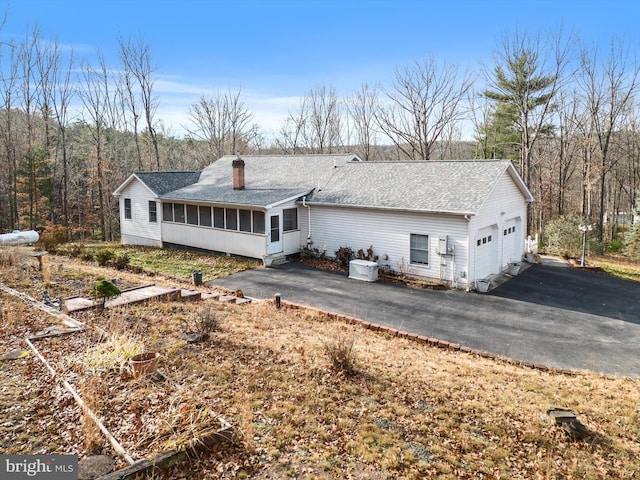 rear view of house with a sunroom and a garage