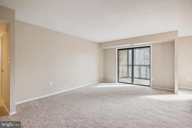 carpeted empty room featuring a textured ceiling