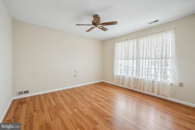 empty room with ceiling fan and light hardwood / wood-style floors