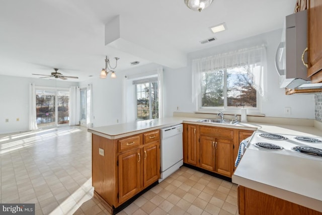 kitchen with kitchen peninsula, white appliances, ceiling fan, and sink