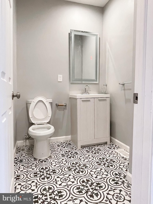 bathroom featuring tile patterned flooring, vanity, and toilet