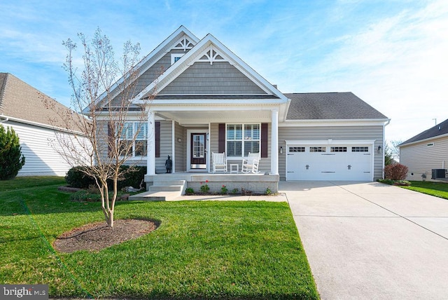 view of front of home with cooling unit, a front lawn, covered porch, and a garage