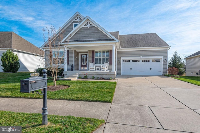 view of front of house with a front lawn, covered porch, and a garage