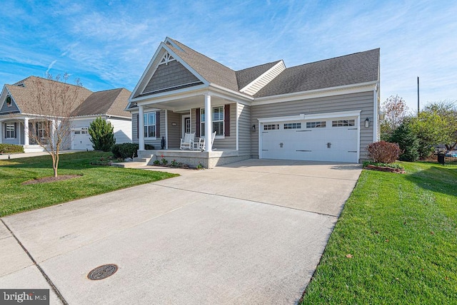 view of front of house with a front lawn, covered porch, and a garage