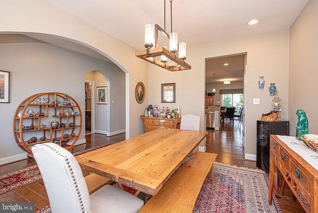 dining space with dark hardwood / wood-style floors and an inviting chandelier